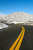 A curvy road showing snow on the ground